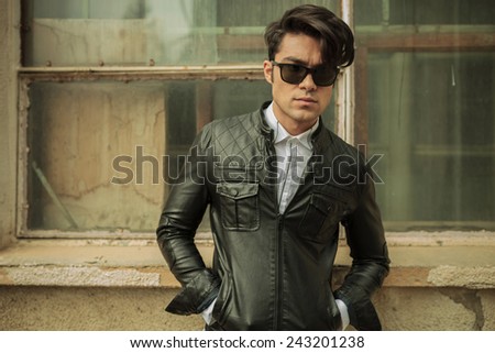 Fashion man posing near old building with his hands in pockets.
