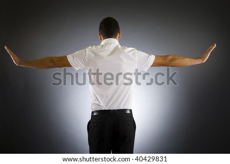 Stock photo of the back side of a well dressed businessman holding his arms up