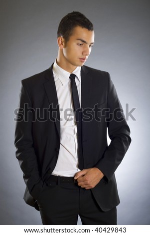 Portrait of a handsome young business man isolated over dark background