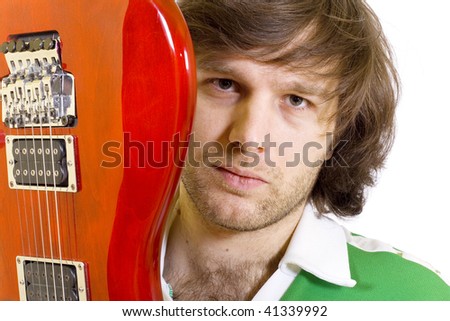 Close up of an electric guitar being held by a guitarist with long hair