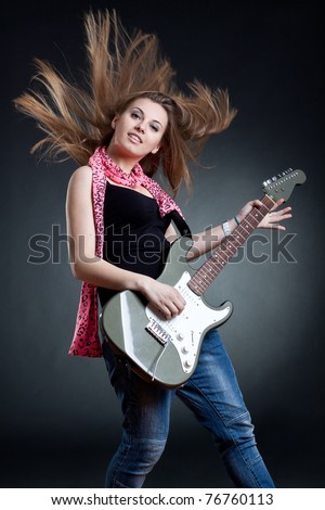 stock photo headbanging woman guitarist playing her guitar over dark 