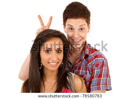 closeup of a young couple - man goofing around behind his girlfriend