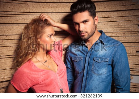 serious, young couple posing with a wood background