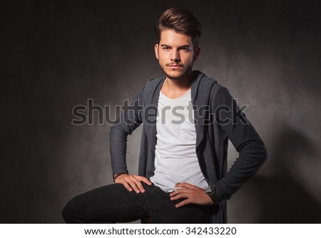 portrait on sexy man posing in studio background with hands on waist looking at the camera