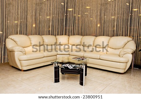 Leather beige angular modern sofa with a coffee table