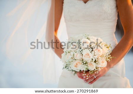 Bride holding wedding bouquet with Roses and Baby\'??s breath flowers