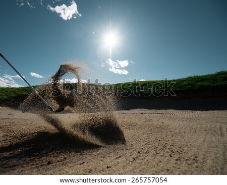 The golf course is on the sand. Sand making splashes
