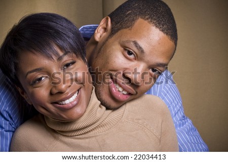 stock photo : A happy couple embraces each other in front of a neutral background in landscape format