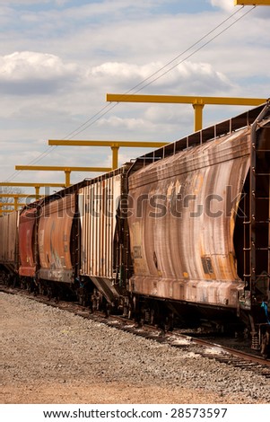 Rusted railcars sitting under a fall-protection system that are waiting to be repaired