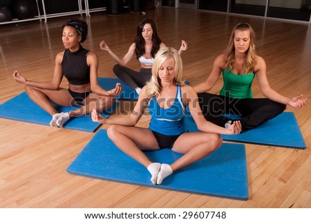 a group of friends does yoga together on a mat meditating