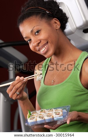 a woman eating sushi at a fitness club