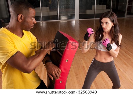 a woman trains with her trainer and is in a punching stance