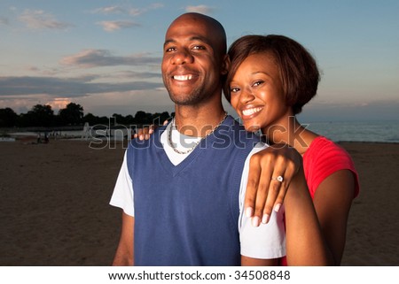 stock photo : a happy couple gets engaged on a beach