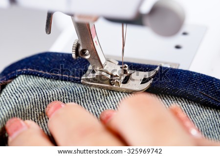 Hemming denim fabric on a sewing machine.