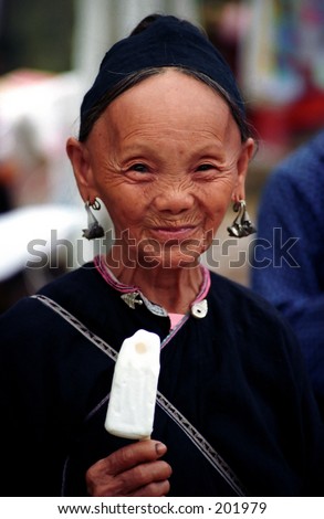 Old Vietnamese woman eating a coconut ice-cream