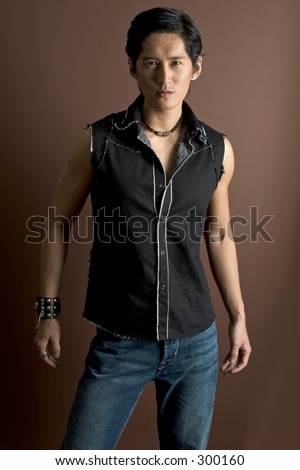 stock photo An asian male model in jeans and a waistcoat