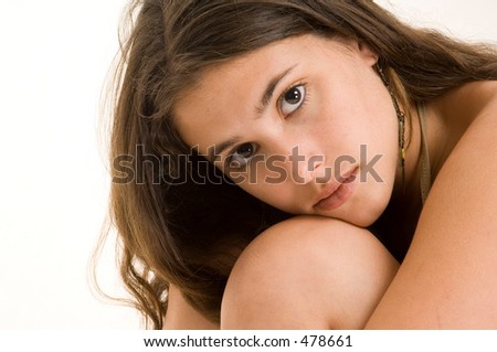 A beautiful and soulful young woman rests her head on her knees