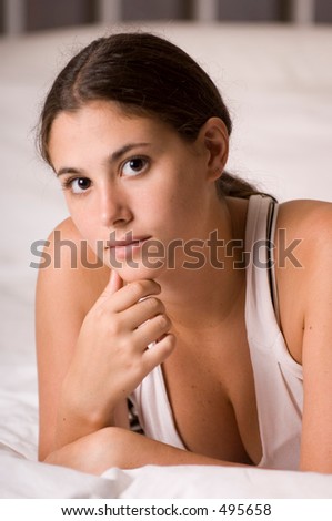 A naturally beautiful young woman lying on a bed