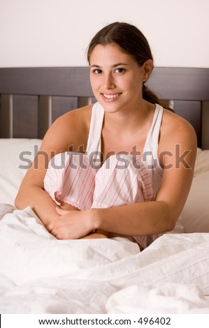 A naturally beautiful model sits on her bed in the morning