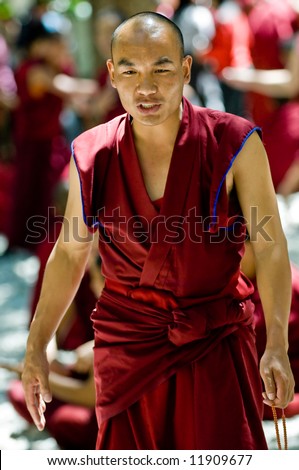 A tibetan monk holding prayer beads
