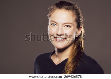 Young Caucasian woman slightly turned away looking at viewer while smiling