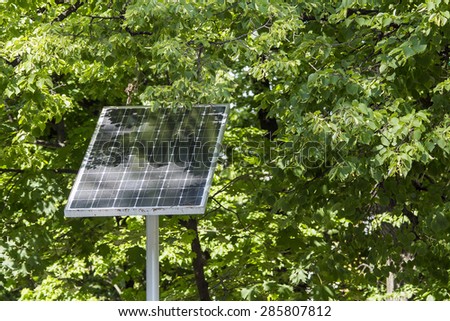 Solar battery on the background of green trees