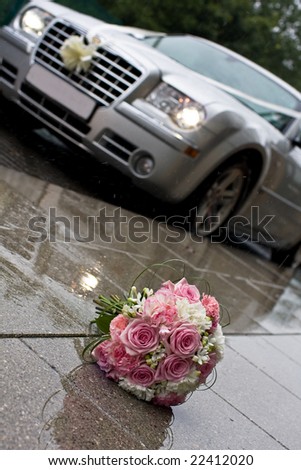 wedding bouquet in the rain in front of a car