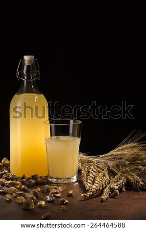 Sour drink made of fermented bread and sugar. Traditional Slavic drink in a glass bottle and with caramelized sugar on black background.