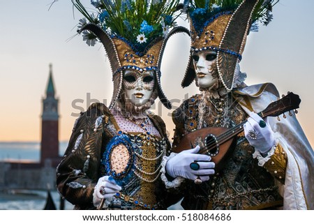 Beautiful couple of masks at St. Mark square during the carnival of Venice.