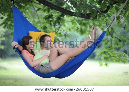 Smiling young couple relax in the hammock