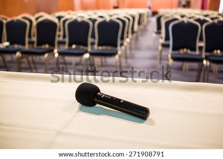 Horizontal shot of microphone and chairs in auditorium