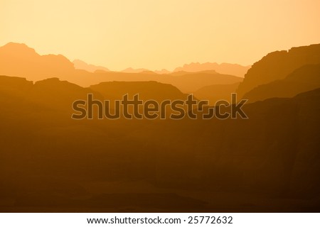 Sun is setting Distant mountains lit by the setting sun in the Wadi Rum desert reservation, Jordan.