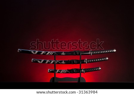 Three ancient japanese swords with a dramatic lighting. Text can be inserted in the upper part of the image.