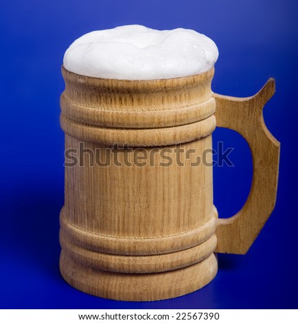 wooden mug with beer on blue background