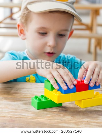 Little boy plays with plastic blocks