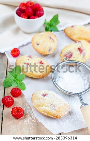 Sugar powdered madeleines with raspberry