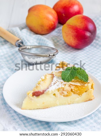 Slice of peach clafoutis on a white plate
