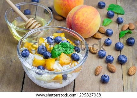 Fresh cottage cheese with peach, blueberry, almonds and honey. Concept of healthy eating for breakfast.