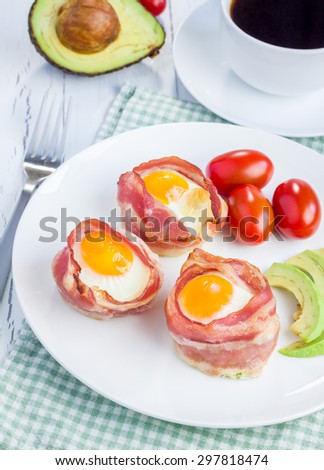 Baked eggs with avocado in bacon cups for breakfast