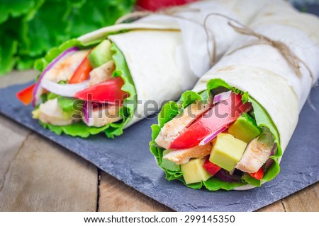 Tortilla wraps with roasted chicken fillet, avocado, tomato, onion and puprika