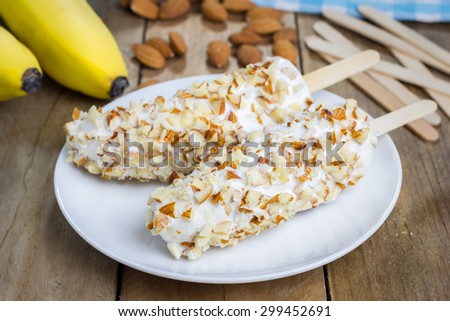 Frozen banana covered with yogurt and almonds