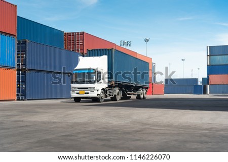 truck with cargo container on road in shipping yard or dock yard against sunrise