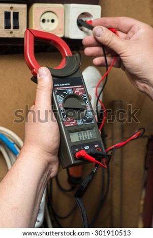 closeup hands of an electrician with electrical voltage meter