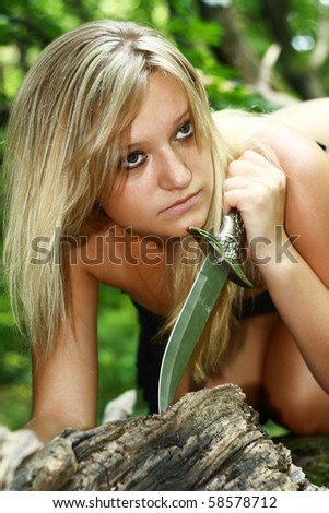 beautiful blonde with dagger in wood