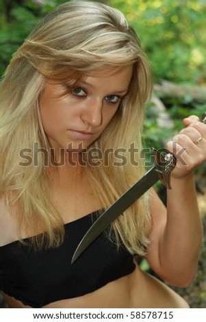 beautiful blonde with dagger in wood