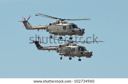 SOUTHPORT, ENGLAND - JULY 23: Two Royal Navy Black Cats Lynx helicopters perform aerobatics and mid air stunts on July 23, 2011 in Southport, England.