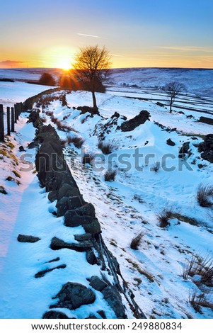 winter scenic with setting sun, snow and dry stone wall. Taken at Crag Vale at the Yorkshire Pennines.