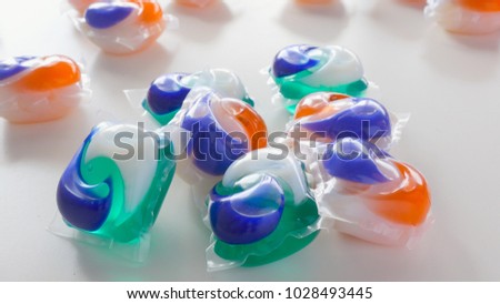 Colorful laundry detergent pods. The green, blue and orange household cleaning products are used in washing machines to clean clothes. A 2018 trend had teens eating the soap as a viral video challenge