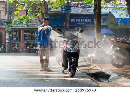 NAMDINH, VIETNAM - April 12, 2015: An men is washing the motobike in Nam Dinh, Vietnam on April 12, 2015. Motobike are popular means transport of VIETNAM.