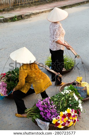 HANOI, VIETNAM - May 2, 2015: Unidentified old woman at the flower small market on May 02, 2015 in Hanoi, Vietnam. This is a small market for retail florists and street vendors.